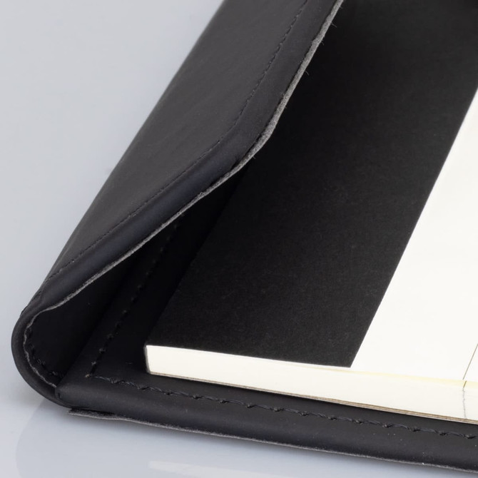 A black notepad holder with a smooth leather finish, featuring an open edge and blank pages inside.
