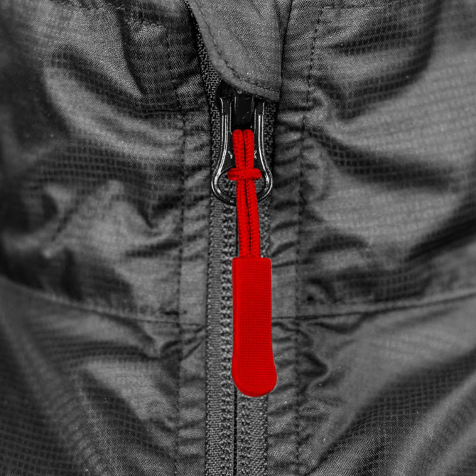 A close-up of a black windbreaker zipper with a red pull tab. The fabric features a subtle textured pattern.