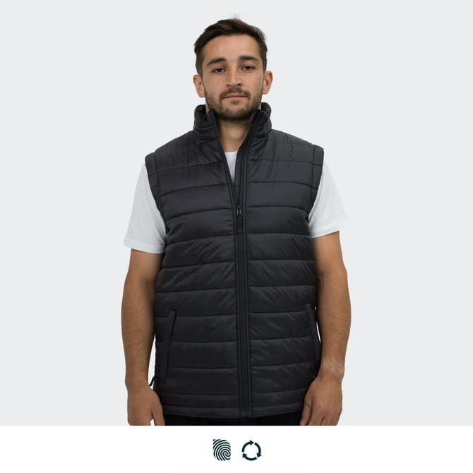 A man wears a black puffer vest with a high collar and two front zip pockets. The vest features a logo.