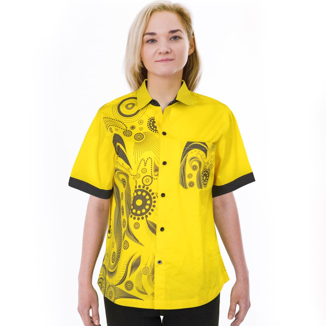 A vibrant yellow women's shirt featuring a black patterned design and contrasting black cuffs. The shirt has a logo.