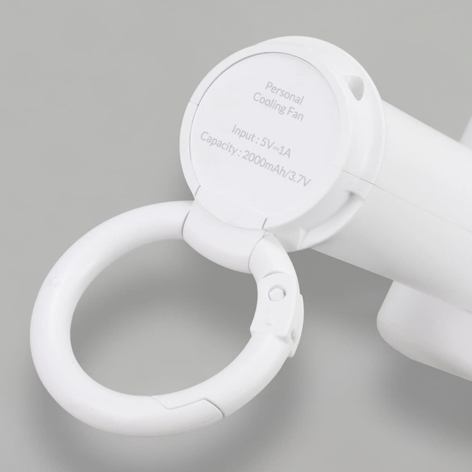 A white personal cooling fan with a carabiner clip and a circular base. It features a branding logo on the side.