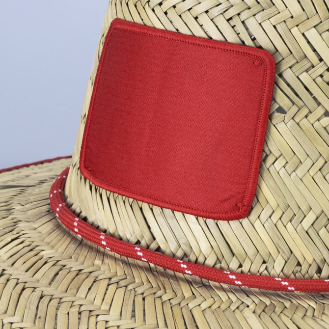 A Tiki straw hat featuring a natural straw body with a red band and a red patch on the front.
