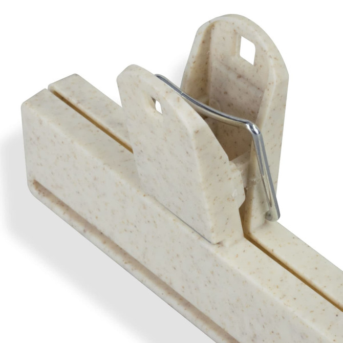 A cream-coloured snack bag clip with a metal spring mechanism for sealing bags. It has two slots and a logo.