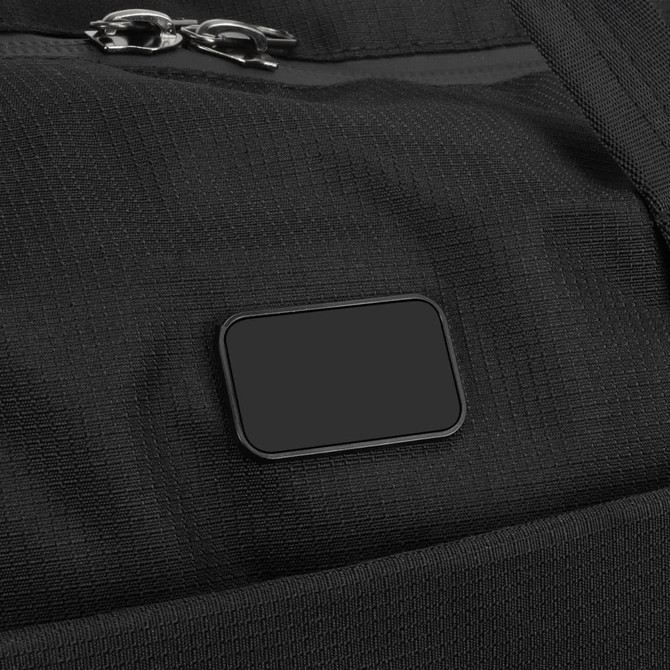 A black duffle bag featuring a zip closure and a branding tag. The material has a textured appearance.