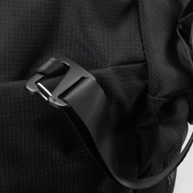 A close-up of a black duffle bag featuring a plastic buckle and strap, showcasing its durable fabric texture.