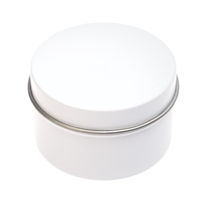A petite candle in a white tin container with a smooth, rounded lid.