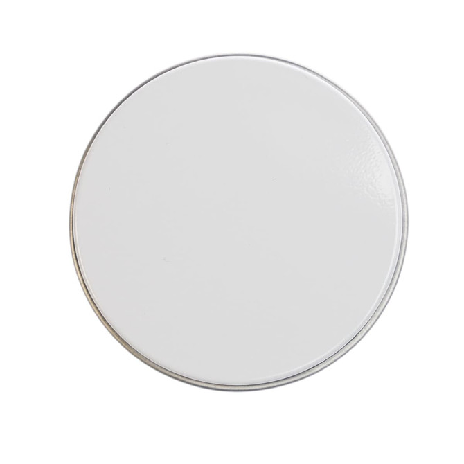 A petite candle in a smooth white tin container.