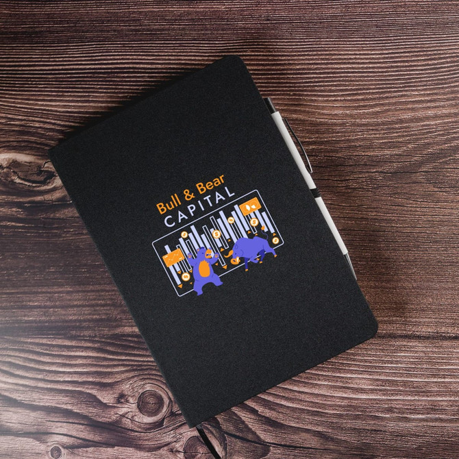 A black A5 notebook featuring a colourful logo with bull and bear illustrations on the cover.