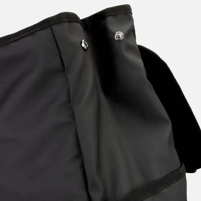 A black backpack featuring a textured fabric, with a closure flap and buttons at the top. It has a logo present.