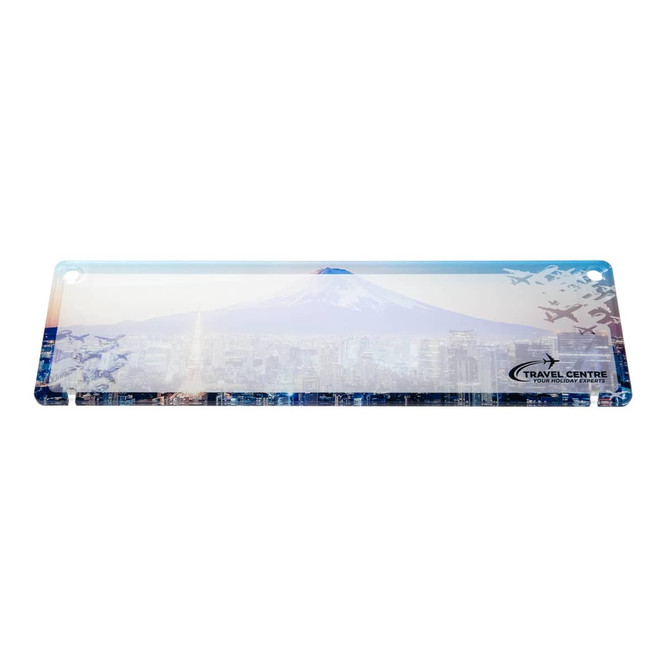 A desk nameplate featuring a scenic design of a mountain and cityscape, along with a logo for a travel center.