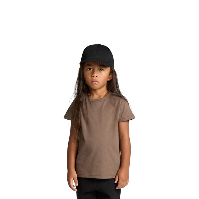 A child wearing a brown staple T-shirt and a black cap, standing with a neutral expression.