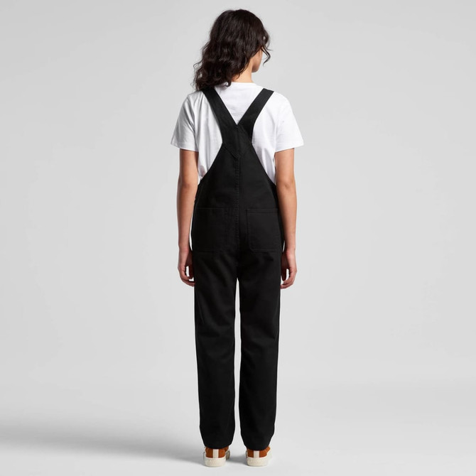 Black canvas overalls worn with a white T-shirt, featuring adjustable straps and a logo on the back.