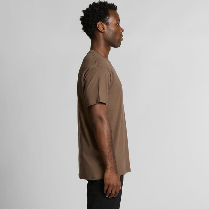 A side view of a man wearing a brown organic T-shirt, featuring short sleeves and a simple design.