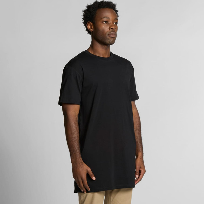 A black Tall Tee t-shirt is displayed on a model standing upright, showcasing its relaxed fit and length.