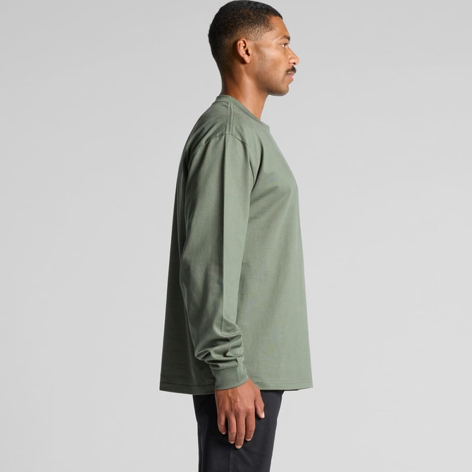 A long-sleeve t-shirt in olive green worn by a person, featuring a logo on the garment.