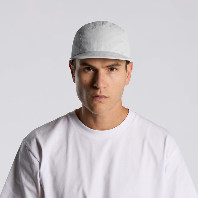 A white nylon cap with a logo, worn by a model in a plain white t-shirt.