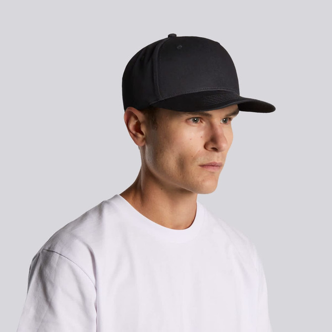 A black cap with a structured design, featuring a curved brim and a logo on the front, worn by a young man.