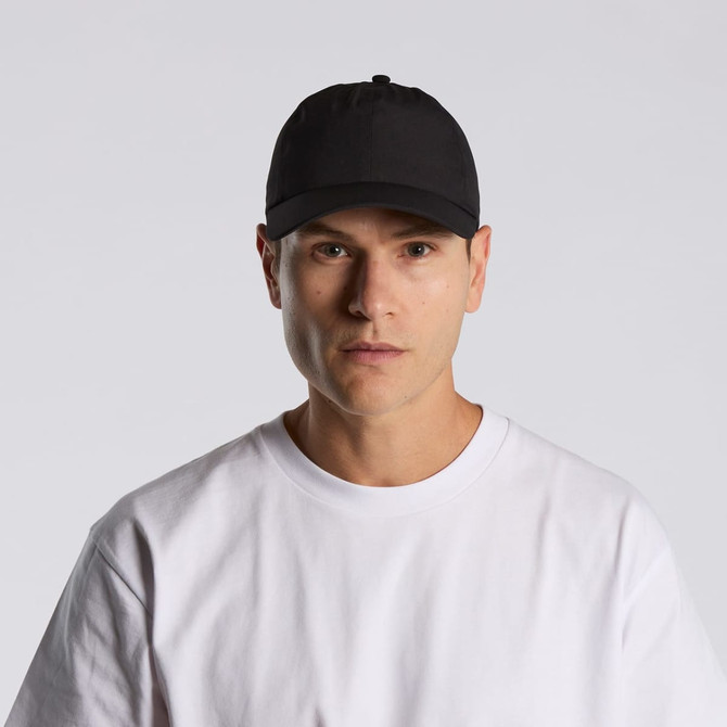 A black cap worn by a person in a plain white t-shirt, featuring a logo on the front.