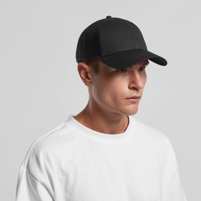 A black trucker cap with a textured mesh back, worn by a model in a plain white T-shirt.