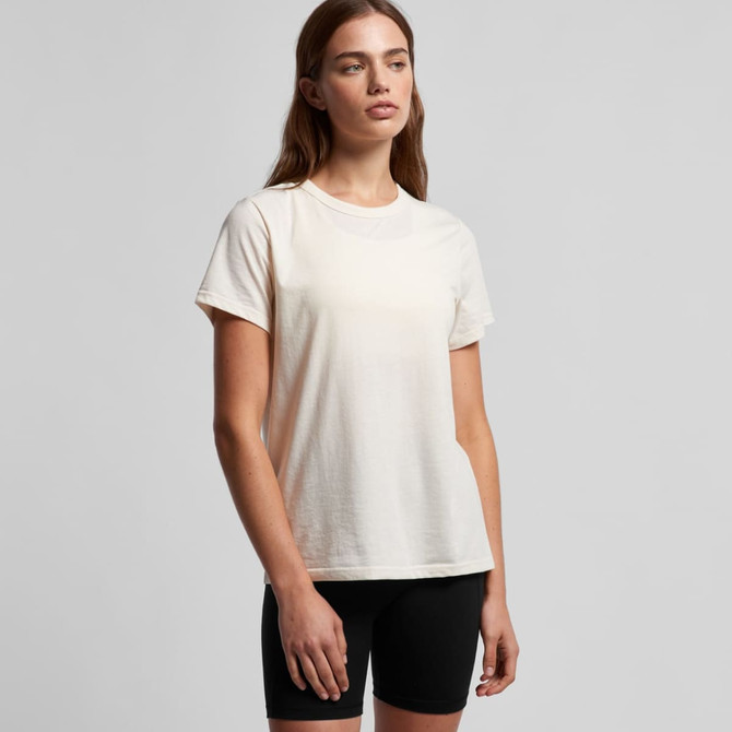 A light cream T-shirt with a relaxed fit, paired with black shorts. The shirt features a logo on it.