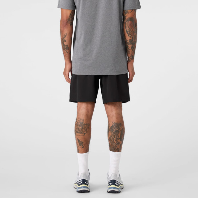 Active Pro Shorts in black, featuring a logo, worn by a person with tattoos, seen from the back.