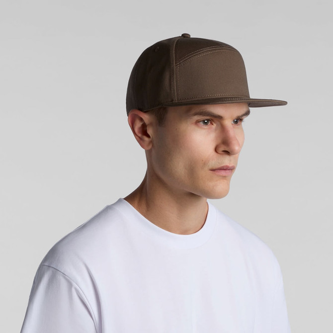 A brown 7-panel cap with a structured design, featuring a flat brim and a logo on the side.
