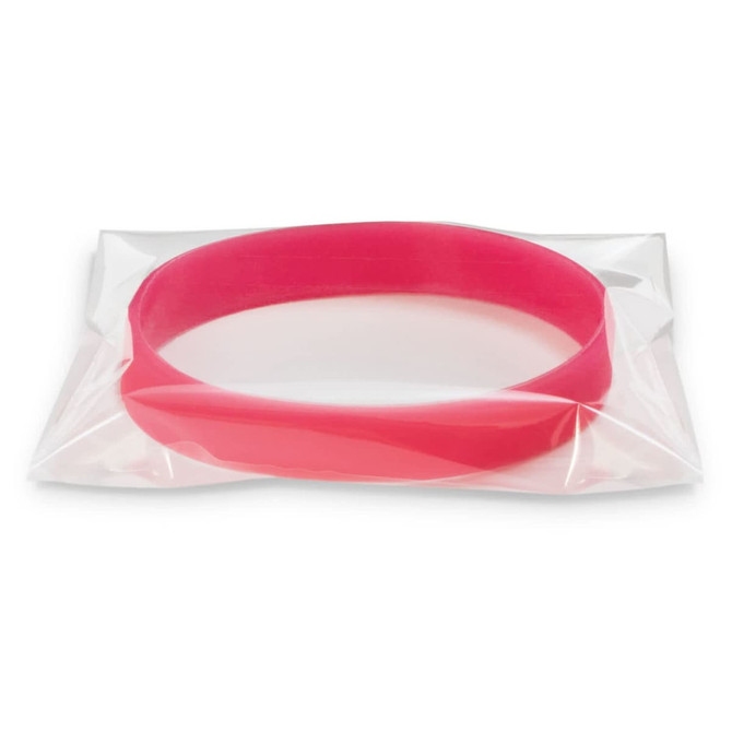 A pink silicone wristband in a clear packaging, designed to glow in the dark. It features a logo.