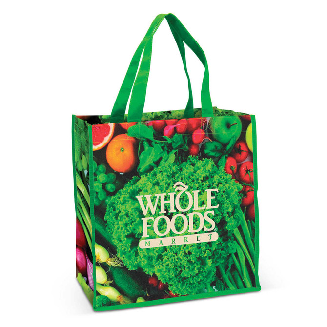 A green tote bag featuring a vibrant print of fresh vegetables and fruits, with a logo on the front.