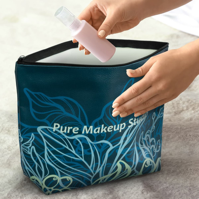 A large teal cosmetic bag with a floral design being opened to reveal a pink spray bottle inside.