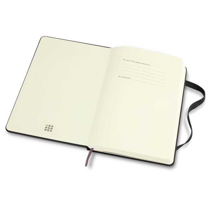 An open Moleskine 2026 planner with blank white pages and a black cover, featuring a ribbon bookmark and a branding logo.