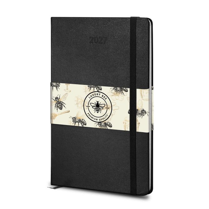 A black Moleskine 2027 planner with a decorative band featuring bees, designed for weekly planning.