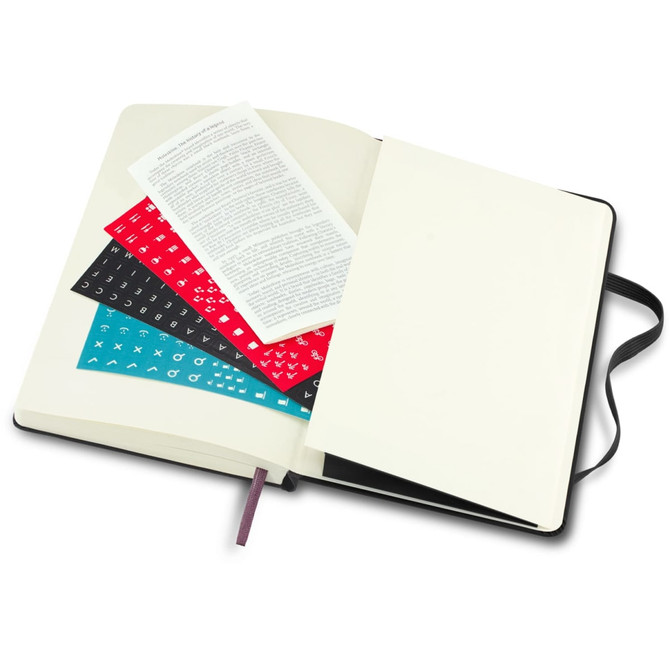An opened Moleskine 2026 Daily Planner with blank pages, featuring colourful stickers and a black ribbon bookmark.