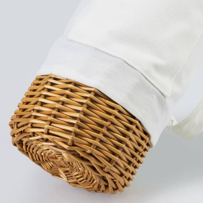 A wicker wine carrier with a white fabric cover, featuring a natural woven base. It has a logo on the fabric.