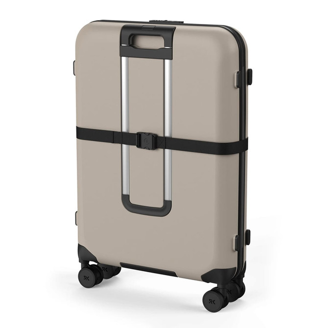 A beige wheeled suitcase with four spinner wheels and a black strap, featuring a minimalist design and a logo.