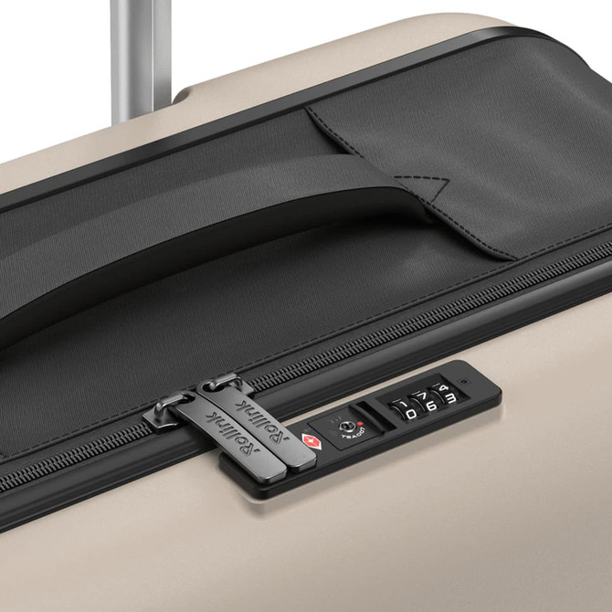 A close-up view of a gold suitcase featuring a black zipper, handle, and a combination lock.