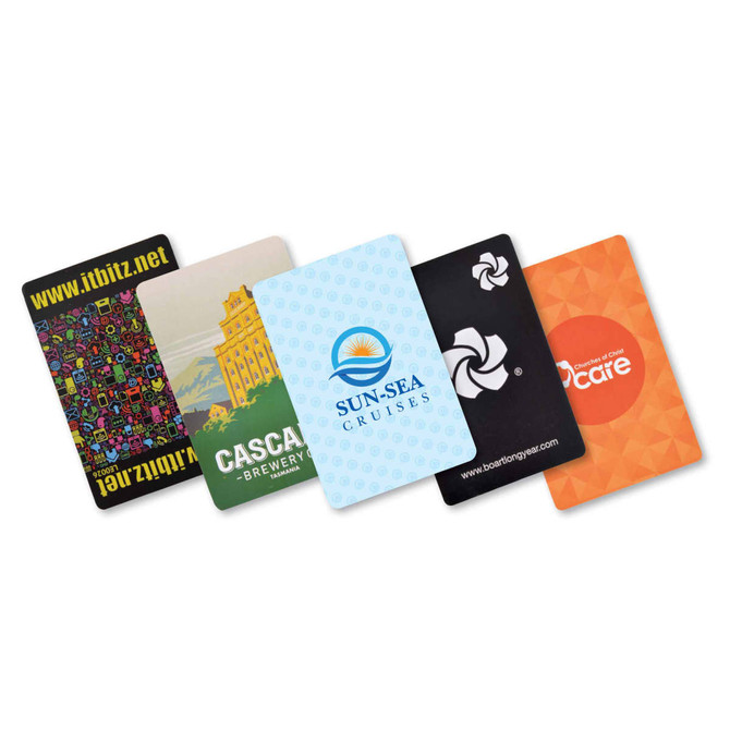 A set of five colorful playing cards featuring various designs and a logo on one card.