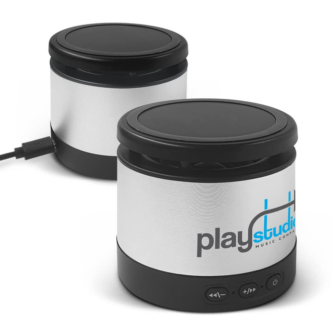 A wireless speaker and charger in silver and black, featuring a logo and control buttons on the base.