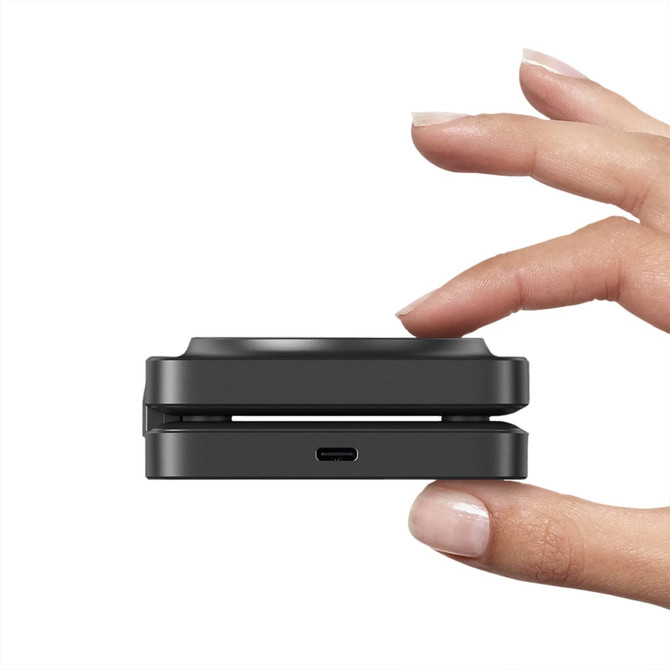 A wireless charger named Tri Power Charger, held in a hand, featuring a sleek, compact design with a USB-C port.