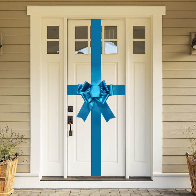 Large bright oversized door bow displayed on a front door for real estate and event presentation