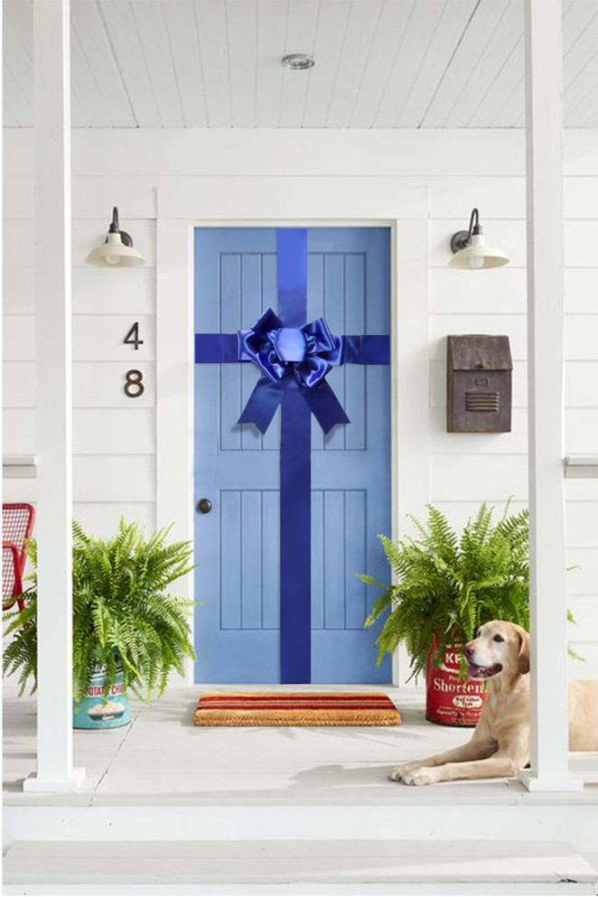 Royal blue oversized door bow displayed on a front door for real estate and event presentation