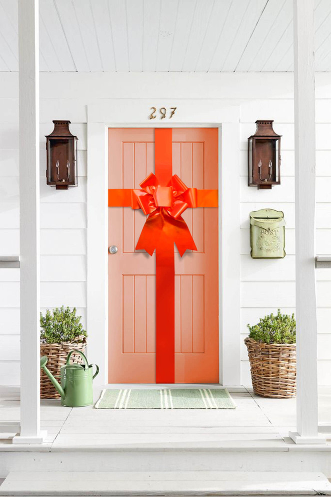 Bright orange oversized door bow mounted on a front door for event displays and promotional styling