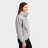 A light grey women's full zip jacket with a high collar and side pockets, featuring a subtle logo.