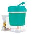 A reusable coffee cup with a teal silicone sleeve and lid, accompanied by a bag of jelly beans.