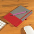 A Venture Bondi Notebook with a red and gray cover is featured alongside a pink Austin Pen on a wooden surface.