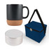 A coffee mug with a cork base, a round portable speaker, and a navy blue insulated bag.