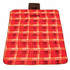 A red and black checkered picnic blanket features a handle for easy carrying and a logo in one corner.