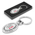 A metal key ring featuring an oval design with the Audi logo, packaged in a sleek black box.