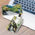 A 4GB credit card-style flash drive with scenic images on both sides, placed near a laptop. Features colour graphics and branding.