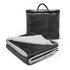 A luxury blanket in dark grey with a soft white underside, folded next to its transparent carrying case.