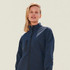A softshell jacket in navy, featuring a zip front and a chest pocket, worn by a model with short hair.